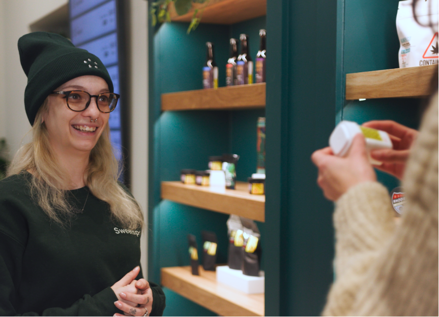 A Sweetspot employee assists a shopper with merchandise.